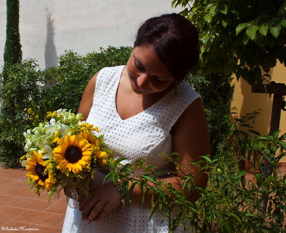 La promessa sposa con il suo bouquet di girasoli